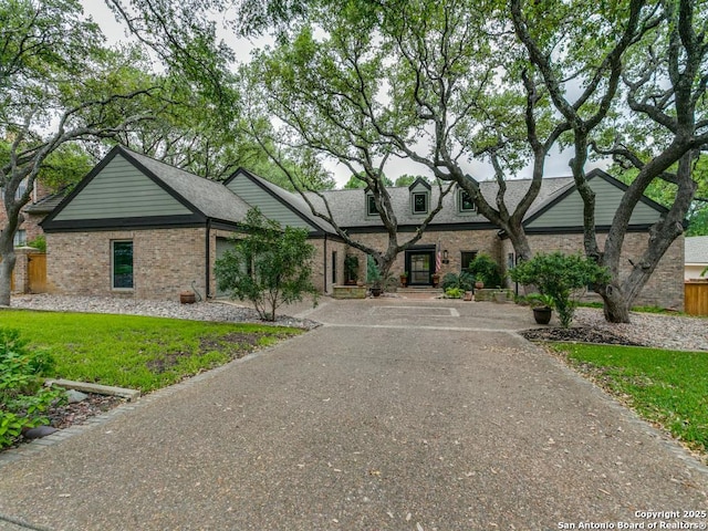 single story home featuring brick siding and a front lawn