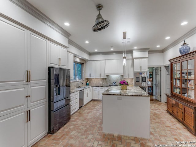 kitchen featuring crown molding, a center island, light stone counters, appliances with stainless steel finishes, and backsplash