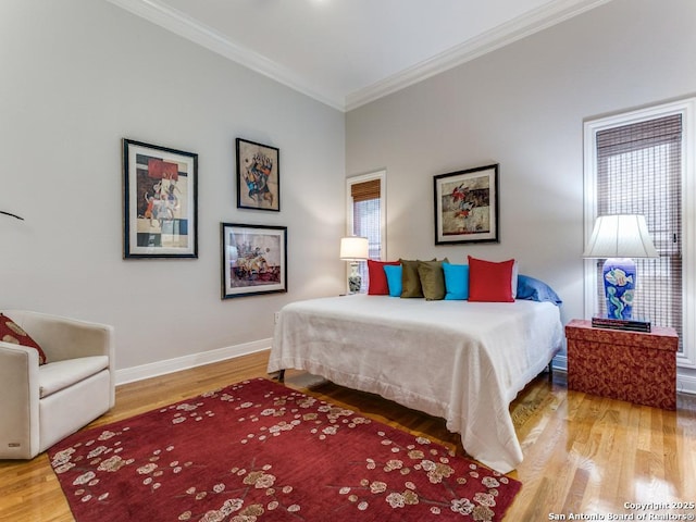 bedroom featuring crown molding, baseboards, and wood finished floors