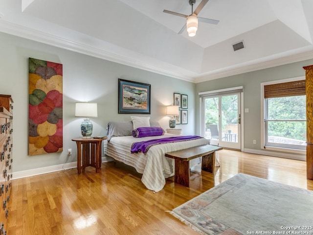 bedroom featuring visible vents, access to exterior, baseboards, light wood finished floors, and a tray ceiling