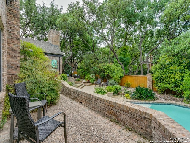 view of yard featuring a fenced in pool, a fenced backyard, and a patio area