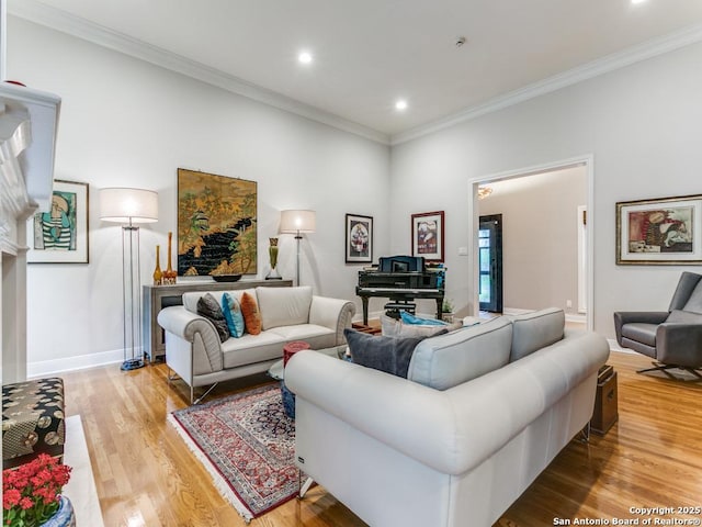 living room featuring recessed lighting, baseboards, ornamental molding, and light wood finished floors