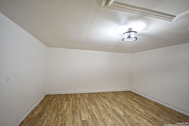 additional living space featuring baseboards and wood finished floors