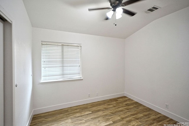 spare room featuring baseboards, a ceiling fan, lofted ceiling, and visible vents