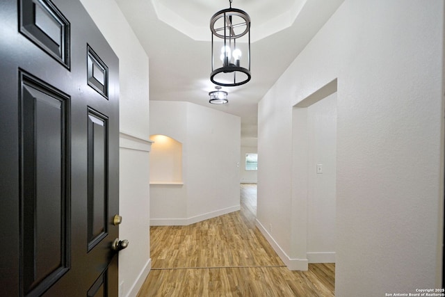 hallway featuring baseboards and light wood finished floors