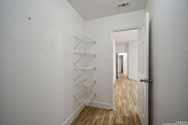 walk in closet featuring visible vents and wood finished floors