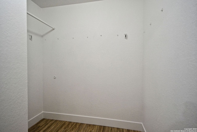 spacious closet with dark wood-style flooring