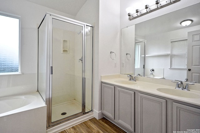 bathroom with double vanity, a sink, a bath, and a shower stall