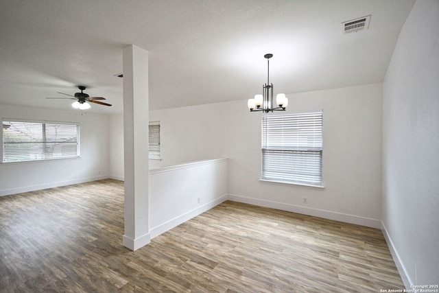 unfurnished room featuring visible vents, baseboards, ceiling fan with notable chandelier, and wood finished floors