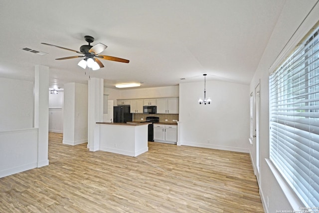 kitchen featuring open floor plan, vaulted ceiling, black appliances, and a wealth of natural light