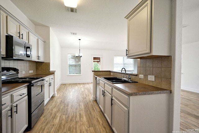 kitchen with range with electric cooktop, visible vents, stainless steel dishwasher, a sink, and light wood-style floors