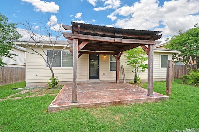 rear view of house with a lawn, fence, and a patio area