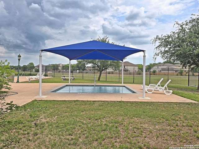 view of swimming pool featuring a yard, fence, a fenced in pool, and a patio area