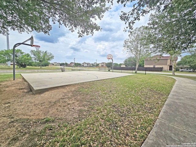 view of sport court with a yard, community basketball court, and fence
