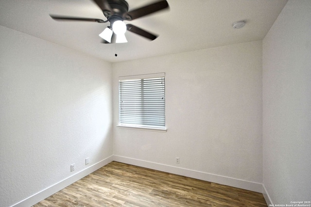 empty room with baseboards, ceiling fan, and wood finished floors
