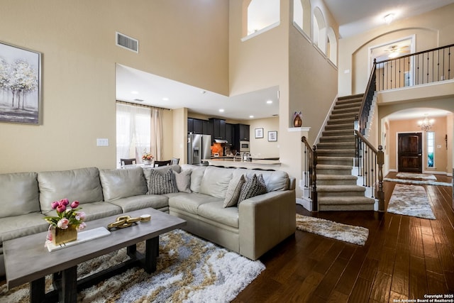 12422 Caprock Crk, San Antonio, TX 78254 - living area with a towering ceiling, arched walkways, stairs, dark wood-type flooring, and visible vents