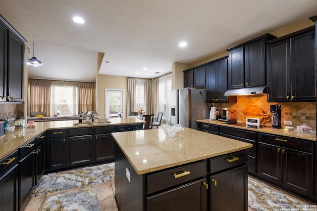 12422 Caprock Crk, San Antonio, TX 78254 - kitchen featuring stainless steel fridge, a sink, a peninsula, under cabinet range hood, and a kitchen island