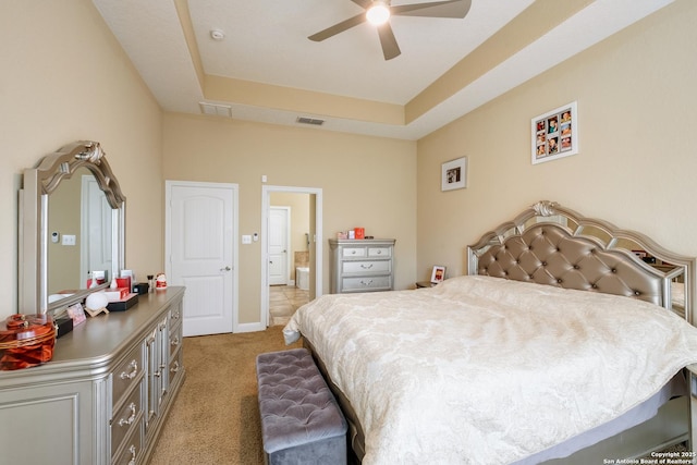 12422 Caprock Crk, San Antonio, TX 78254 - bedroom featuring visible vents, ensuite bathroom, a tray ceiling, and light colored carpet