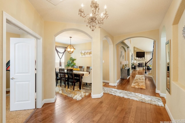 12422 Caprock Crk, San Antonio, TX 78254 - foyer with arched walkways, stairs, a notable chandelier, and hardwood / wood-style flooring
