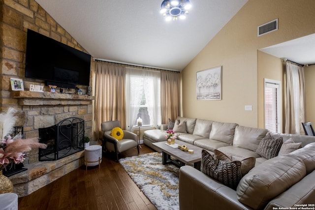 12422 Caprock Crk, San Antonio, TX 78254 - living room featuring dark wood-style flooring, high vaulted ceiling, visible vents, and a stone fireplace