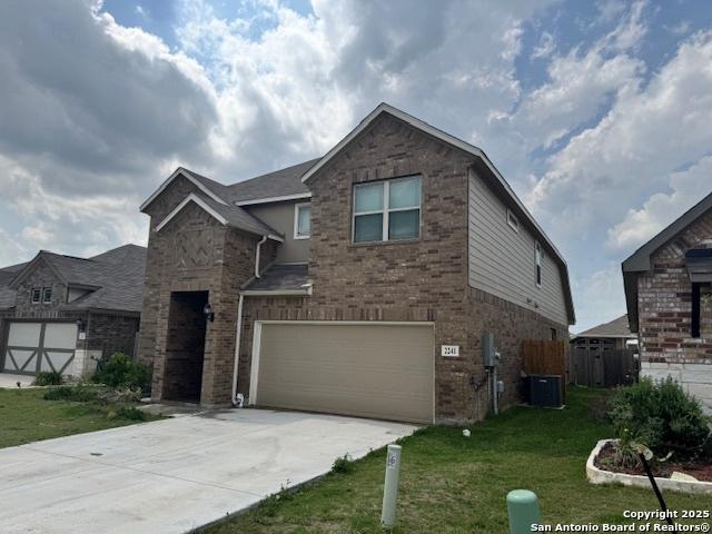 view of front of home featuring a garage, a front lawn, central AC, brick siding, and driveway