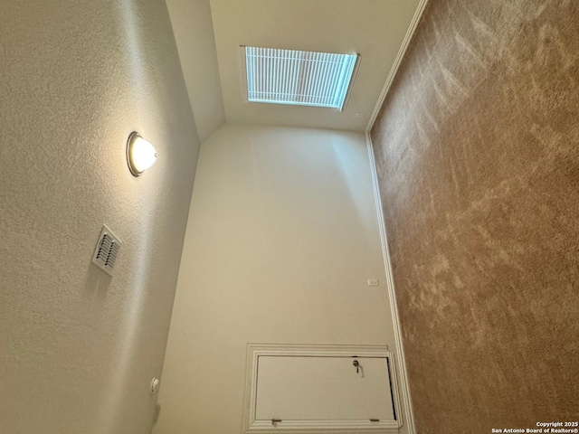 empty room featuring a textured wall and visible vents