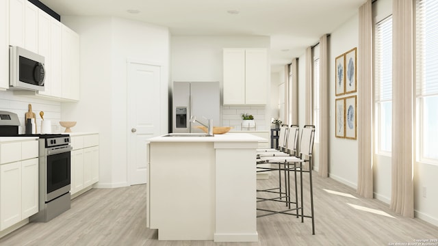 5219 Whirling Pl, San Antonio, TX 78253 - kitchen featuring light wood-style floors, appliances with stainless steel finishes, tasteful backsplash, and a kitchen island with sink