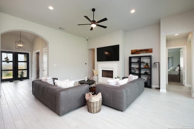 living room featuring visible vents, a fireplace, ceiling fan, recessed lighting, and arched walkways