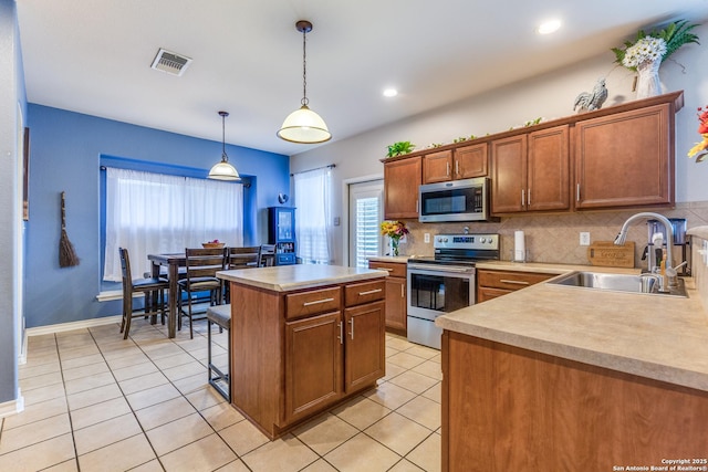 kitchen with light countertops, appliances with stainless steel finishes, a wealth of natural light, and a sink