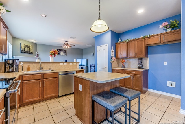 kitchen with backsplash, brown cabinets, light countertops, a sink, and stainless steel appliances
