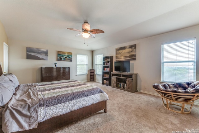 bedroom with light colored carpet, a ceiling fan, and baseboards