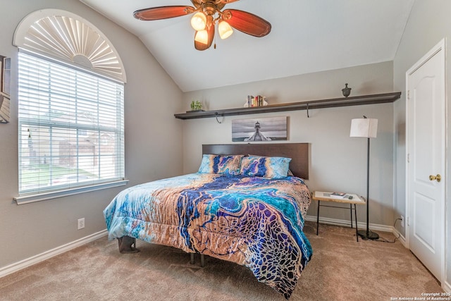 carpeted bedroom with a ceiling fan, baseboards, vaulted ceiling, and multiple windows