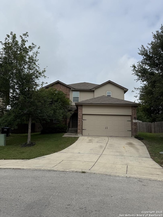 traditional-style home featuring fence, an attached garage, brick siding, a front yard, and concrete driveway