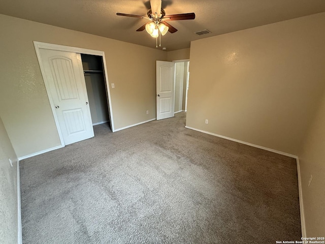 unfurnished bedroom with carpet floors, visible vents, a closet, baseboards, and a ceiling fan