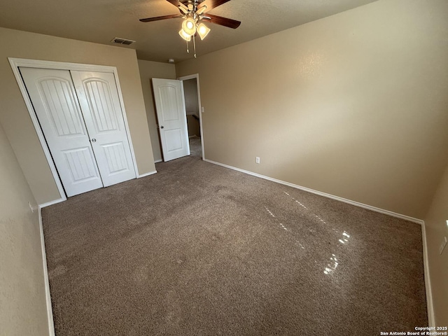unfurnished bedroom featuring carpet, a ceiling fan, baseboards, visible vents, and a closet
