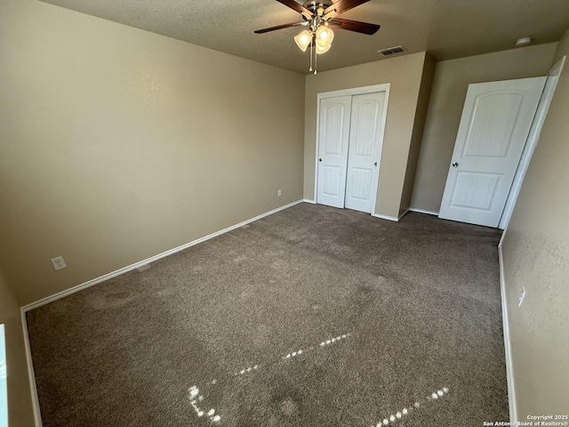 unfurnished bedroom featuring carpet floors, a ceiling fan, baseboards, visible vents, and a closet