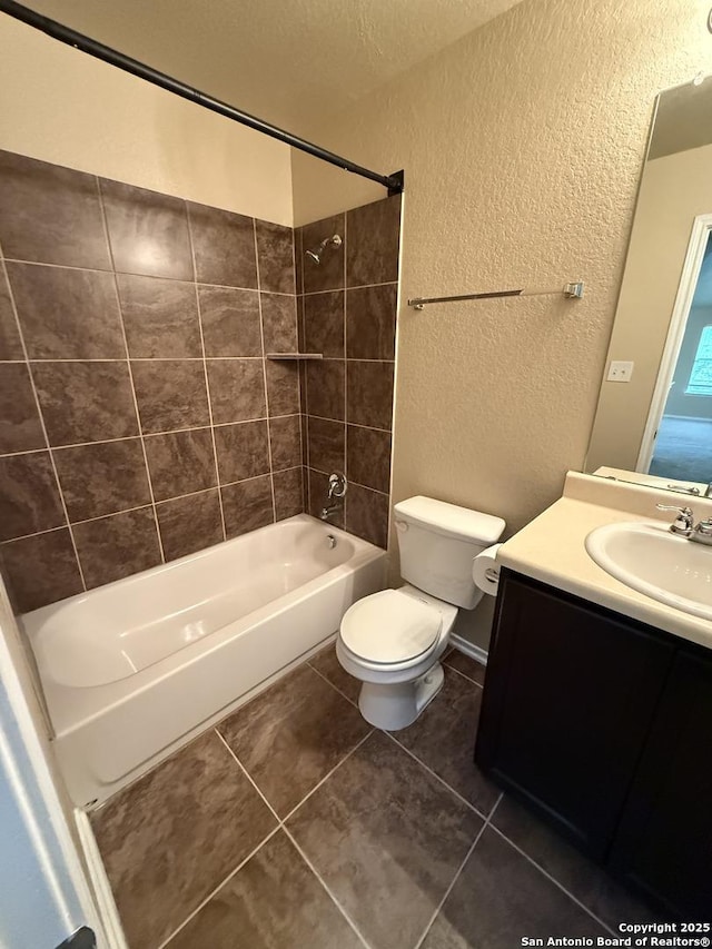 bathroom featuring tile patterned flooring, bathtub / shower combination, vanity, toilet, and a textured wall