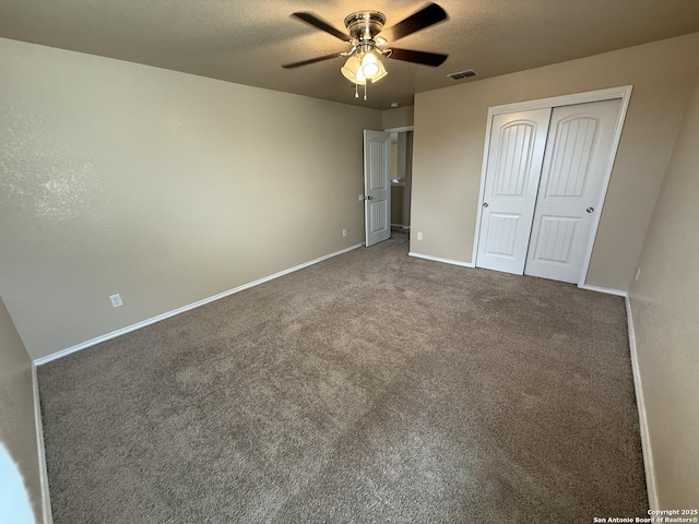 unfurnished bedroom with visible vents, carpet floors, a closet, baseboards, and a ceiling fan