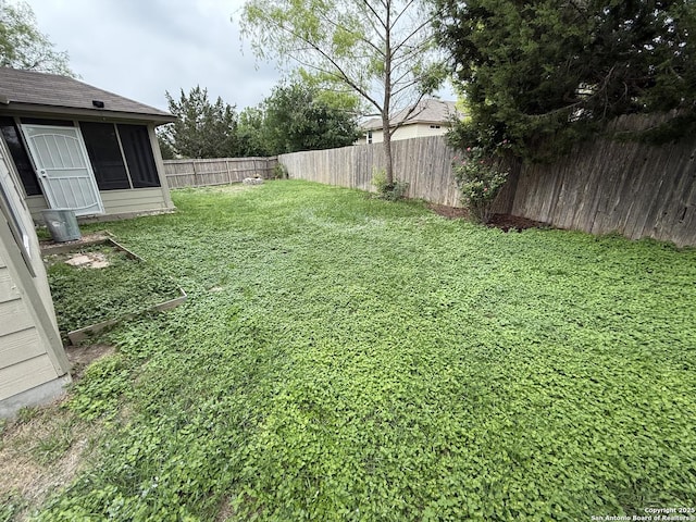 view of yard with a fenced backyard and a sunroom