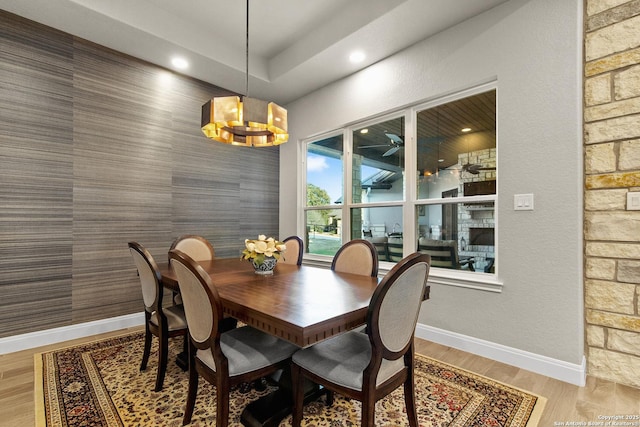 dining space with baseboards, recessed lighting, an accent wall, and a notable chandelier