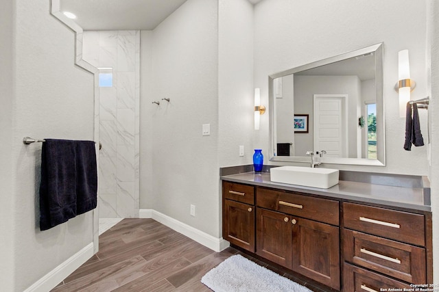 bathroom featuring vanity, baseboards, and wood finished floors
