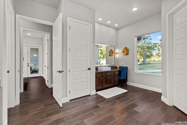 bar featuring recessed lighting, baseboards, dark wood-style floors, and a sink