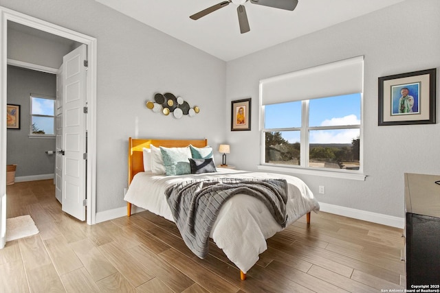 bedroom featuring baseboards, a ceiling fan, and wood finished floors
