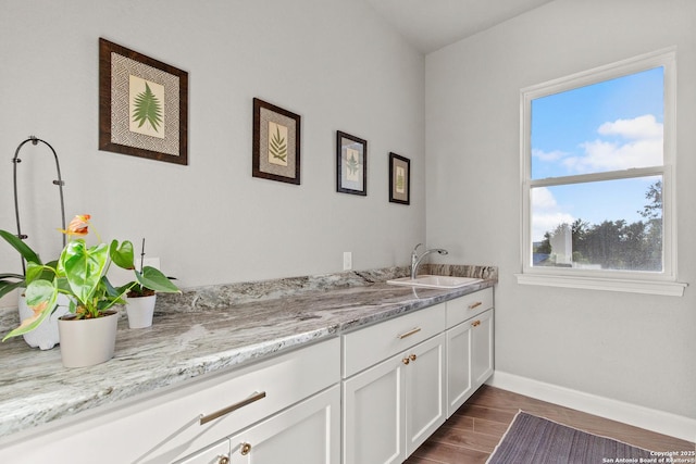 bathroom featuring baseboards, wood finished floors, and vanity