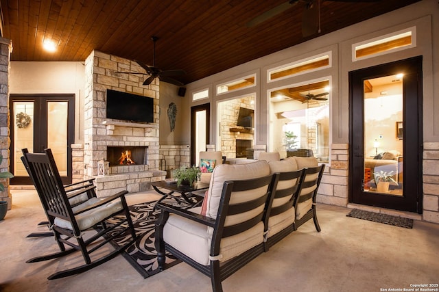 view of patio with a ceiling fan and an outdoor living space with a fireplace
