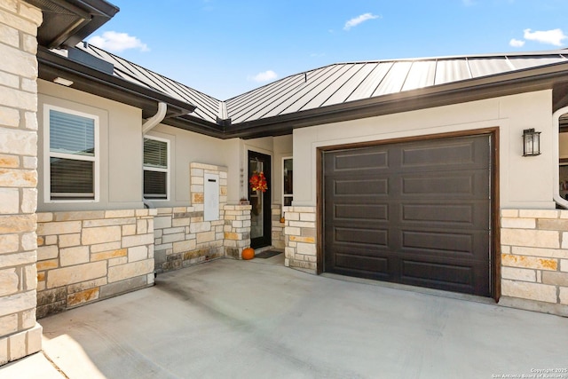 property entrance featuring a standing seam roof, an attached garage, metal roof, and stone siding