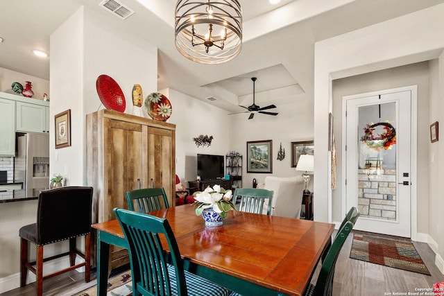 dining area featuring visible vents, wood finished floors, baseboards, recessed lighting, and a raised ceiling