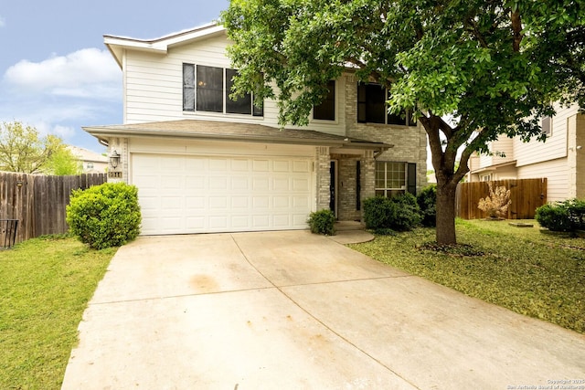 traditional-style house with concrete driveway, an attached garage, fence, and a front lawn
