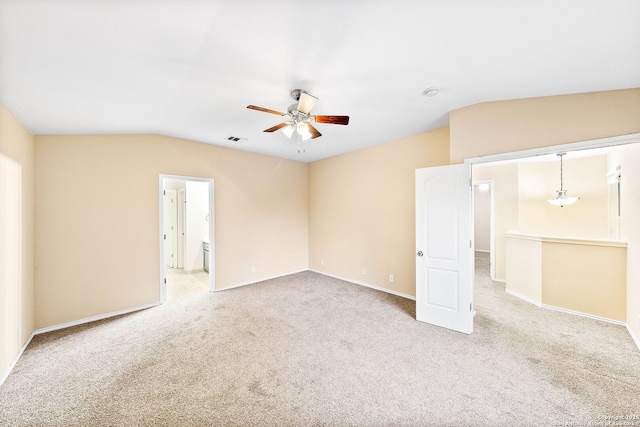 interior space with carpet flooring, a ceiling fan, baseboards, lofted ceiling, and visible vents