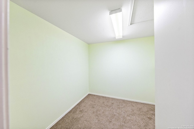 carpeted spare room featuring baseboards